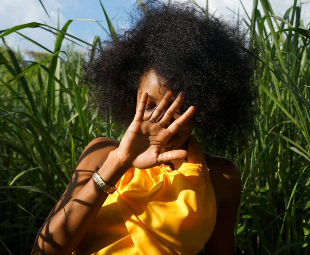 photo of woman hiding her face using her right hand